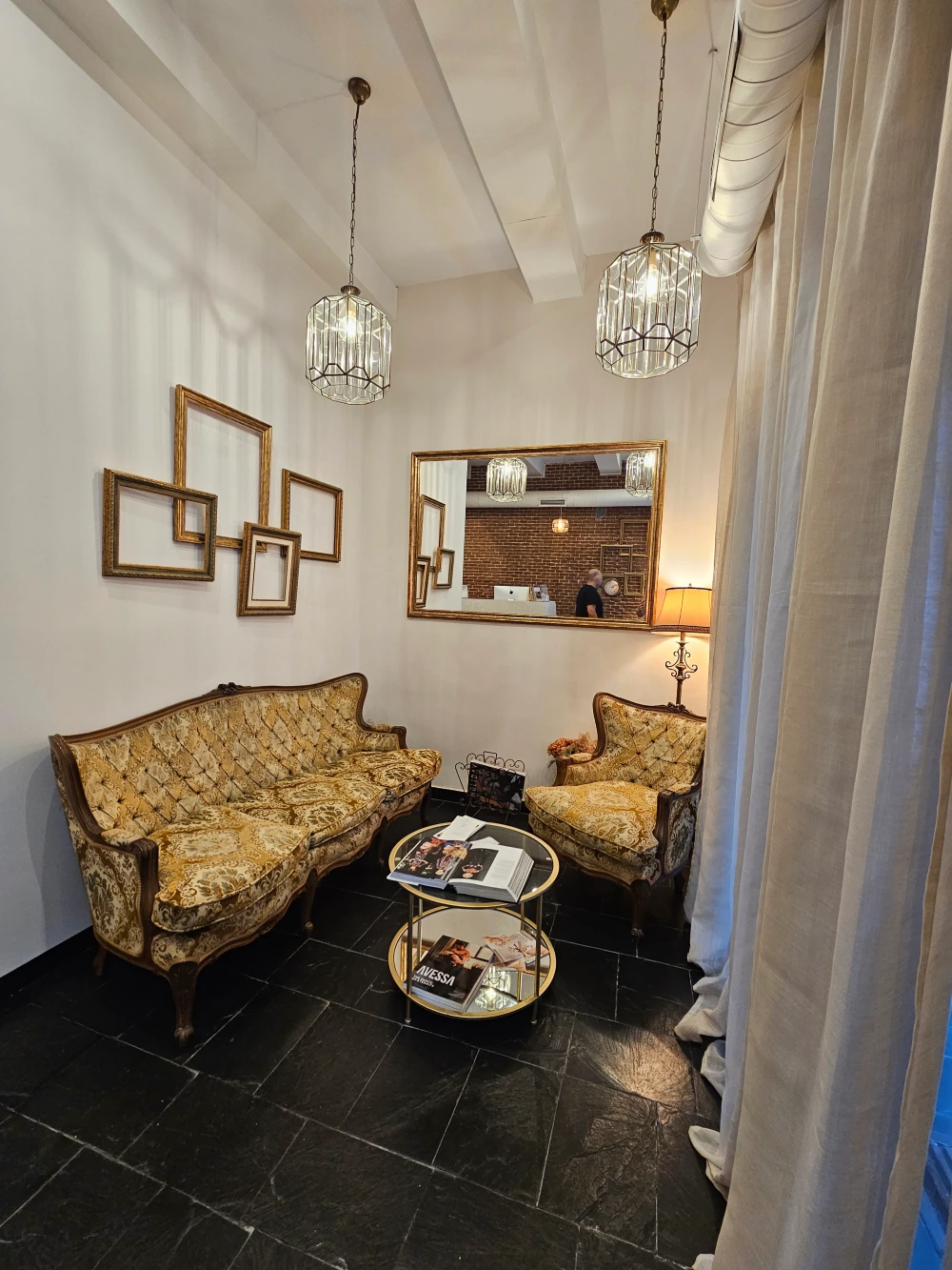 Sala de espera premium de Lúmina Clinic en Madrid con sofás y sillones en tonos beige, espejo arqueado e iluminación cálida.